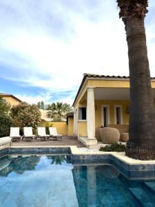 - une piscine avec un palmier à côté d'une maison dans l'établissement Villa Yoléa avec piscine privée au Grau du Roi Vacances de rêve, au Grau-du-Roi 38 autres photos