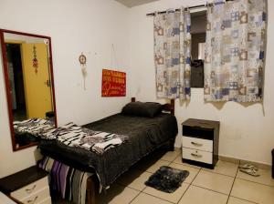 a bedroom with a bed and a mirror in it at República Relicário in Ouro Preto
