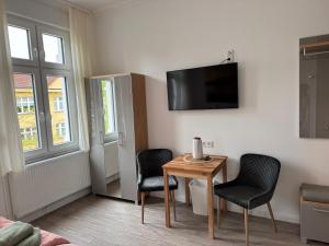 a room with two chairs and a table and a tv at Downtown 38 in Wittenberge