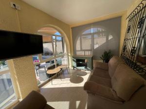 a living room with a couch and a flat screen tv at PARADISE GARDEN in Los Alcázares