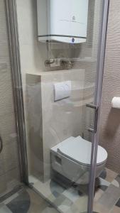 a bathroom with a toilet and a paper dispenser at Innova TravelVir - Salt and Sun in Vir +55 photos