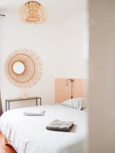 a bedroom with a white bed and a mirror at Casëto Luberon in Apt
