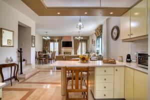 AtsipopouloにあるMariliza's Spacious Maisonette Close to Beachesのテーブルと椅子のあるキッチンとリビングルーム