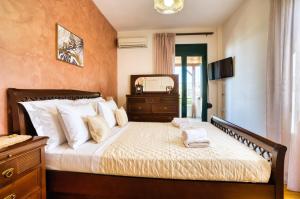 AtsipopouloにあるMariliza's Spacious Maisonette Close to Beachesのドレッサーと鏡付きのベッドのある寝室