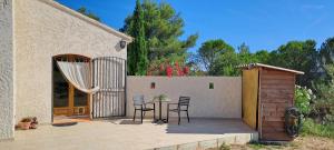 a patio with a table and chairs and a fence at La Ribasse en Provence in Venelles