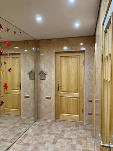 einen Flur mit zwei Holztüren in einem Zimmer in der Unterkunft Просторная квартира, Калиновая 66, левый берег in Nizhnedneprovsk + 6 Fotos