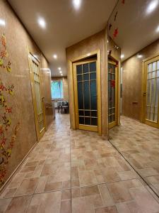 einen leeren Flur mit Türen und Fliesenböden in der Unterkunft Просторная квартира, Калиновая 66, левый берег in Nizhnedneprovsk