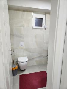 ein kleines Badezimmer mit Toilette und Fenster in der Unterkunft ViA prime central location in Ohrid + 3 Fotos