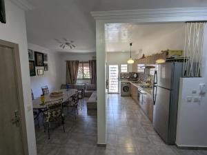 a kitchen and living room with a table and a refrigerator at Dar SAÏDA in Marrakesh