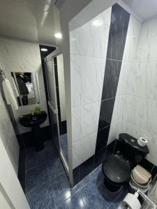 a bathroom with a toilet and a sink and a mirror at Hotel Valle del Café - Habitación 11 para Grupos de 4 Personas in Sevilla