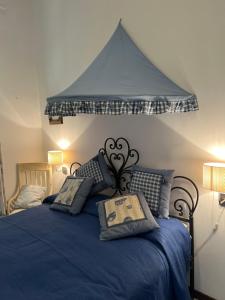 a bedroom with a blue bed with a canopy at Casa Bacot in Canneto