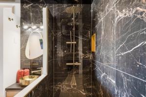 a bathroom with black marble walls and a shower at Le Daïquiri Renovated Apartment with Terrace in the Naturist Village in Cap d'Agde