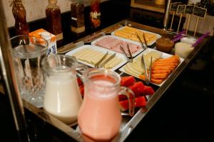 a tray of food with cheese and meats and milk at Villarejo Parque Hotel in Penha