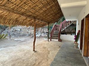 a porch of a house with a straw roof at Casa lucia in Zipolite