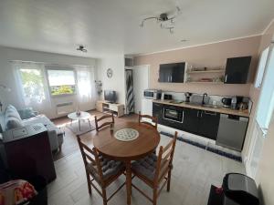 Hem-MonacuにあるLe petit coin de la Haute Sommeのテーブルと椅子のあるキッチンとリビングルーム