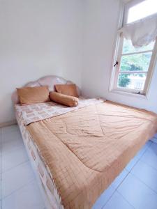 una cama grande en una habitación con ventana en villa puncak Resort by akuvila, en Puncak