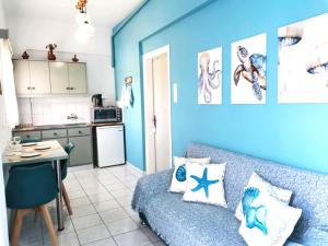 a blue living room with a couch and a kitchen at Valentino Apartment Kalymnos in Panormos Kalymnos
