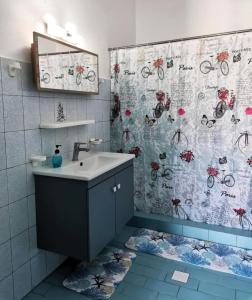 a bathroom with a sink and a shower curtain at Valentino Apartment Kalymnos in Panormos Kalymnos