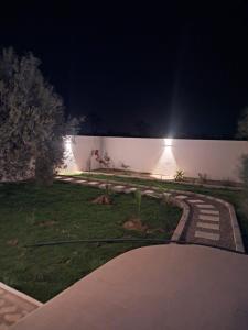 a garden at night with a light on a wall at Villa Djerba hood in Banī Dinhet