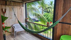 a hammock on the porch of a house at Posada Nore, Nuquí in Arusí +16 photos
