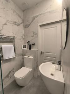 a white bathroom with a toilet and a sink at Ponti House Dilijan - beautiful 2 bedroom house and separate 1 bed unit, sleeps 6 in Dilijan +24 photos