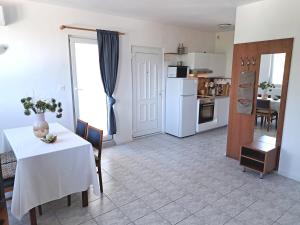 Una sala de estar con una mesa y una cocina. en Rosana, en Nečujam 24 fotos más
