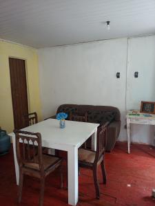 a living room with a table and chairs and a couch at Se sinta em casa nessas férias in Igrejinha