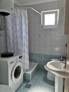 Un baño con lavadora y lavabo. en Rosana, en Nečujam