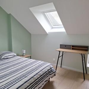 a bedroom with a bed and a skylight at Ma Petite Maison in Belz