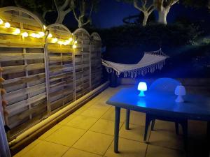 a table and chairs on a patio at night at T1 Familial avec Terrasse, Piscine, Plage à 6 Min à Pied et Aqualand à 2 Min in Cap d'Agde +4 photos