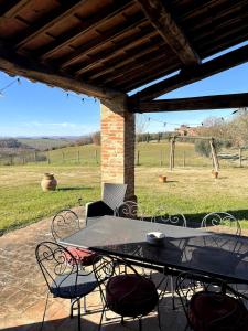 a table and chairs on a patio with a view of a field at Villa Bellora in Cortona