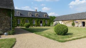 an old stone house with a grass yard at La Petite Lande in Ménil