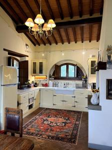 a large kitchen with white cabinets and a rug at Villa Bellora in Cortona