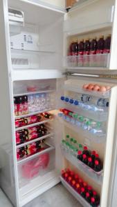 an open refrigerator filled with lots of drinks and eggs at Kos di Menteng, Jakarta Pusat in Jakarta