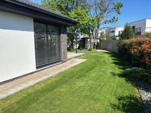 Hrubá BoršaVila GOLF的一座房子旁的绿草庭院