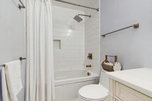 a white bathroom with a tub and a toilet at Cupid's Nest in Edisto Beach +18 photos