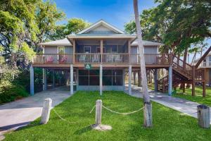 a house with a wrap around porch with a deck at Cupid's Nest in Edisto Beach