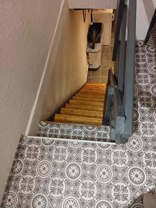 a staircase with a tiled floor and a stair case with a tile floor at la p'tite maison d'olima in Épinal
