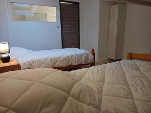 a bedroom with two beds and a lamp and a window at la p'tite maison d'olima in Épinal