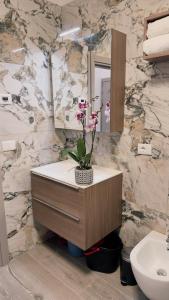 a bathroom with a sink and a counter with flowers on it at Appartment Alleghe center in Alleghe