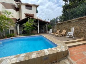 a swimming pool in front of a house at L Otro Pueblo Pampatar in Pampatar