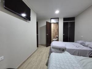 um quarto com duas camas e uma TV de tela plana em SunTemple em San José