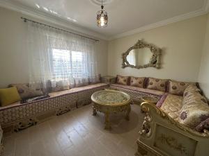 a living room with a couch and a table at Appartement à Houma, proche Port Tanger Med in Dalia