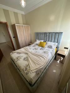 a bedroom with a bed with a gray headboard at Appartement à Houma, proche Port Tanger Med in Dalia