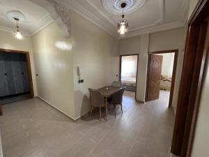 a dining room with a table and chairs in a room at Appartement à Houma, proche Port Tanger Med in Dalia
