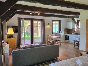 a living room with a couch and a table and a kitchen at Altes Backhaus Bauernhof Vogel in Rohrsen