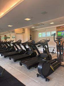 a row of exercise bikes in a gym at Suite na Barra - Rio Centro - Parque Olímpico in Rio de Janeiro