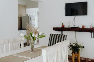 a dining room table with a vase of flowers on it at Los Geranios Apart in Villa Cubas