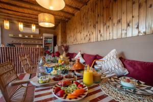 a table with plates of food and fruit on it at Riad Tassili Boutique in Marrakesh