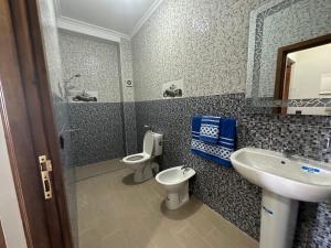 a bathroom with a sink and a toilet and a shower at Appartement à Houma, proche Port Tanger Med in Dalia +37 photos